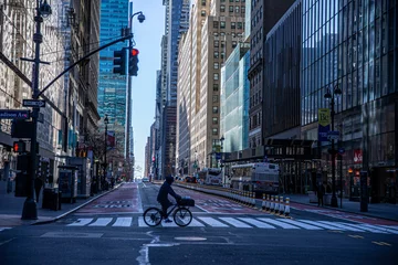 Tuinposter A person rides his bike through the near empty streets near Grand Central due to health concerns to stop the spread of Coronavirus in New York City on Tuesday, March 24, 2020. (Photo: Gordon Donovan). © GORDON