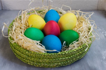 Colored eggs in a green basket