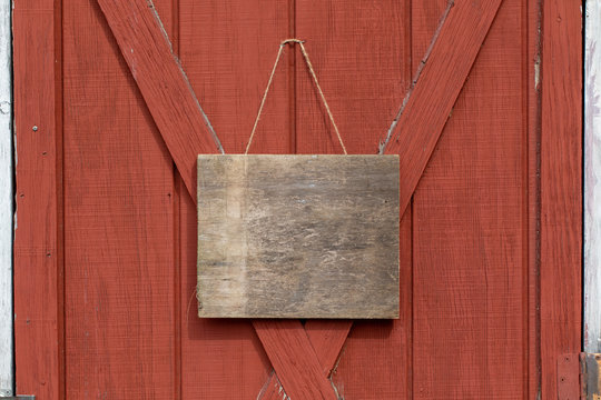 old weathered wooden sign hang on a barn door 