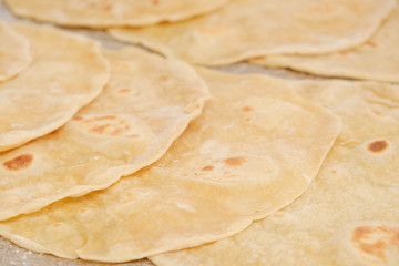Stack of homemade whole wheat flour tortilla on wooden table
