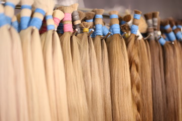 Various colors of straight single clip in human hair extensions. Making natural wigs.