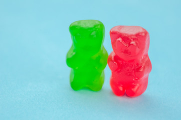 Two marmalade bears stand among other marmalade bears on a blue background, macro