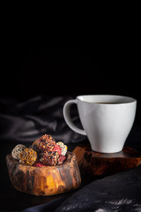 cup of coffee, chocolate candies and cookies on table