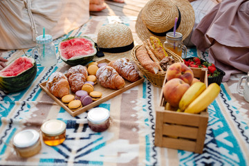 Picnic at the park. Fresh fruits, ice cold sparkling drinks and croissants on a hot summer day. Picnic lunch. selective focus