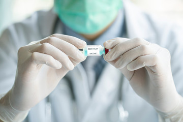 Medical Doctor holding bottle with 2019-nCoV vaccine for treat patients.