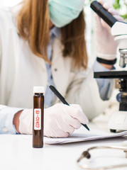 Scientist in laboratory working with microscope. Covid-19 concept.