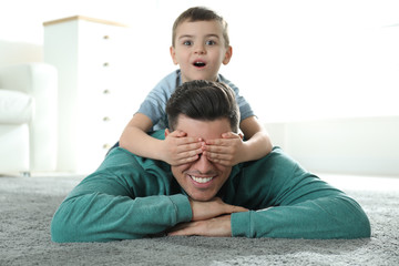 Fototapeta premium Dad and son spending time together at home. Happy Father's Day
