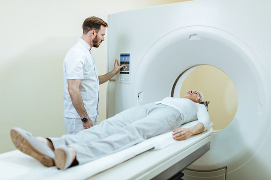 Radiologist preparing female patient for CT scan examination in the hospital.