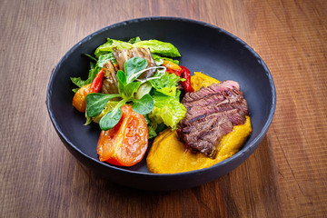 Juicy steak medium rare beef with green salad on plate. Top view, flat lay