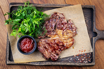 Grilled ribeye beef steak, herbs and spices. Top view.