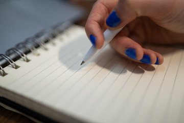 Kobieta pisze długopisem w notesie plany do zrobienia - obrazy, fototapety, plakaty