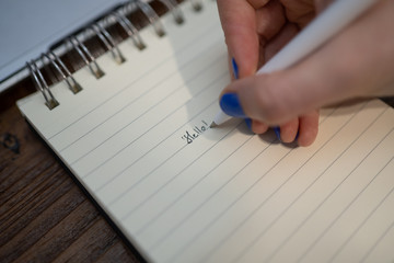 Kobieta pisze długopisem w notesie plany do zrobienia