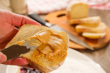 peanut butter sandwich. Cutting board, Kitchen knife, hand.