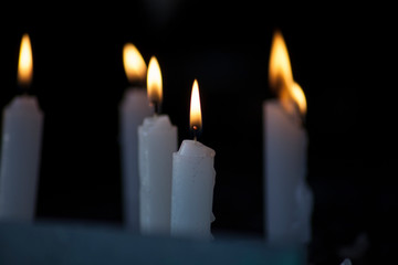 White Candles flames lighting in Darkness 
