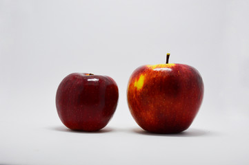  two red, juicy, ripe apples on a white background. apples are a source of iron and vitamins
