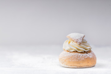 Fototapeta na wymiar Semla, a traditional scandinavian cream filled cardamom bun with almond paste