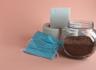 The concept of panic, buckwheat toilet paper and medical masks on a colored background, panic...