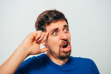 finger to his temple. A man shooting with a finger on his head. Desperate stressed young businessman with finger to his temple like a gun