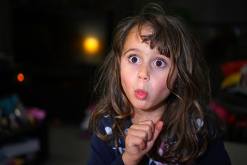Naklejka premium little girl with big eyes make funny faces, with copy space