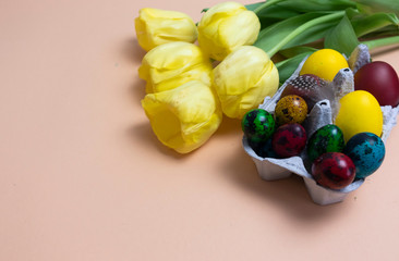 On a pink background are yellow flowers and a tray with colorful eggs