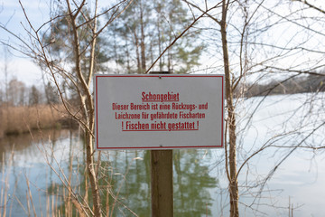 Schild für Schongebiet eines Fisch Laichplatzes - Fischen nicht gestattet.