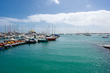 Fototapeta premium Corralejo, Fuerteventura, Canary Islands, Spain: Boats and Yachts in Corralejo Port, calm ocean water 