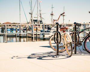  Bicycle with Perfect Shadow Parked Next to the Waterfront, Boats and Water in Background