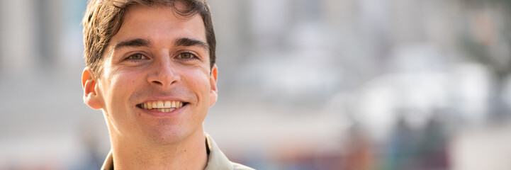 Obraz premium Portrait of young smiling man isolated on outside outdoor background