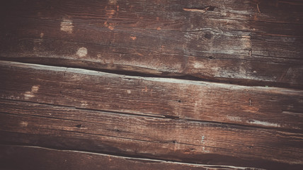 Element of an old wooden fence. The texture is uneven with cracks and scuffs.