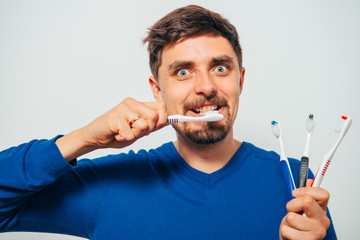 man holding toothbrushes