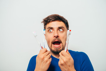man holding toothbrushes