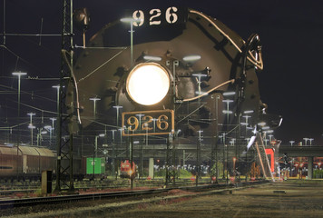 Vintage locomotive superimposed on nighttime train yard nobody