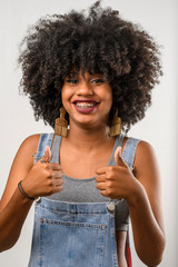 linda jovem afro brasileira, com cabelo estilo afro demonstrando o cuidado com o cabelo