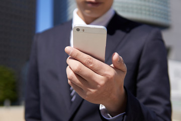 スマートフォンを操作する日本人男性ビジネスマン