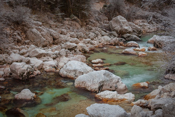 Cold winter river or stream in the mountains, winding between rocks and stones.