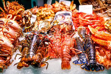 Fresh crabs, lobsters. langustas and shrimps on ice in the Barcelona fish market