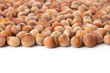 Close up view of shelled Hazelnuts isolated on white. Heap of Hazelnuts as background.