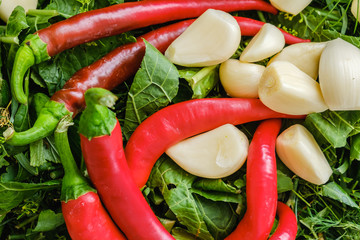 hot peppers and garlic on greens background, healthy food