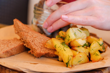 Plate of pieces of herring with fried potato,onion. Close up with selective focus.