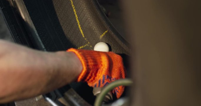 View of male hand in gloves skiving the tire patch with electro emery