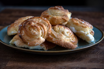 Homemade round cheesecakes, cottage cheese in the dough, in a plate on a wooden table in the kitchen.