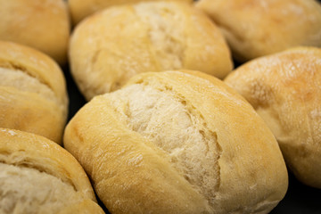 loaves of crisp, golden wheat bread fresh from a bakery on gray wooden background