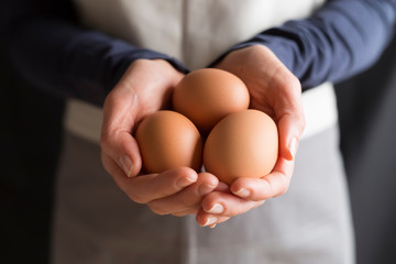 Raw chicken eggs in woman's hands. - Powered by Adobe