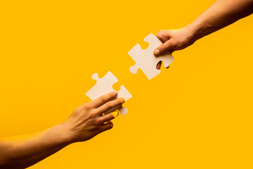 Closeup hands of man connecting jigsaw puzzle. Business solutions, success and strategy concept....