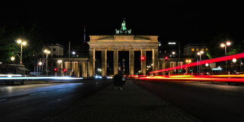 Fototapeta na wymiar Long exposure picture of Brandenburg Gate (Brandenburger Tor) and traffic light trails at night, in Mitte, Berlin