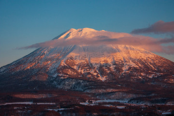 Mount Yotei during a pink sunset in the clouds at Lake Toya in Japan