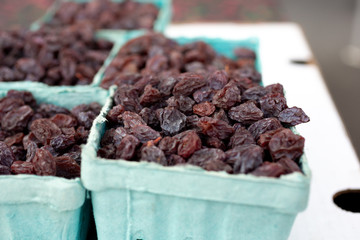 A closeup view of several cartons of raisins, or sun dried grapes, on display at a local farmers market.
