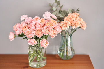 Flowers in glass vase on wooden table. Fresh cut flowers for decoration home. Delivery flower.