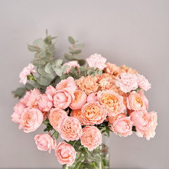 Flowers in glass vase on wooden table. Fresh cut flowers for decoration home. Delivery flower.