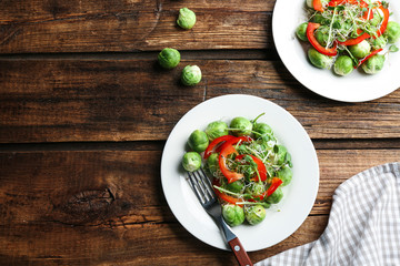 Tasty salad with Brussels sprouts served on wooden table, flat lay. Space for text